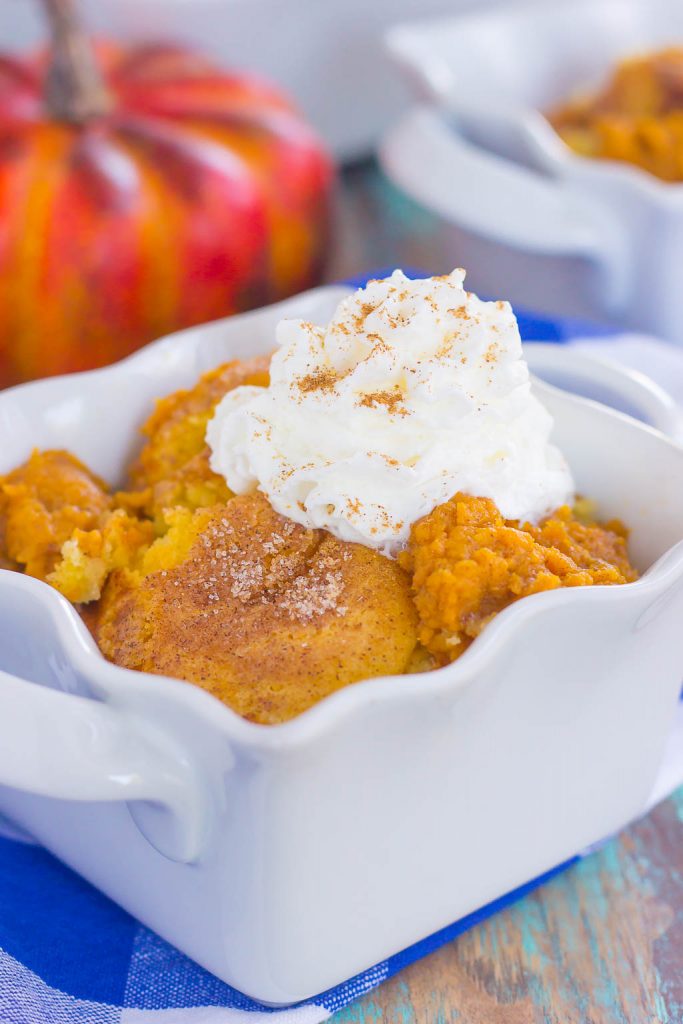 cobbler in a white baking dish topped with whipped cream