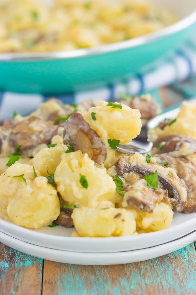 zoomed in shot of fork taking a scoop of gnocchi pasta with cream sauce