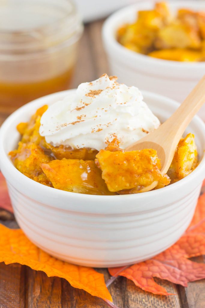 pumpkin bread pudding in a white bowl with a spoon