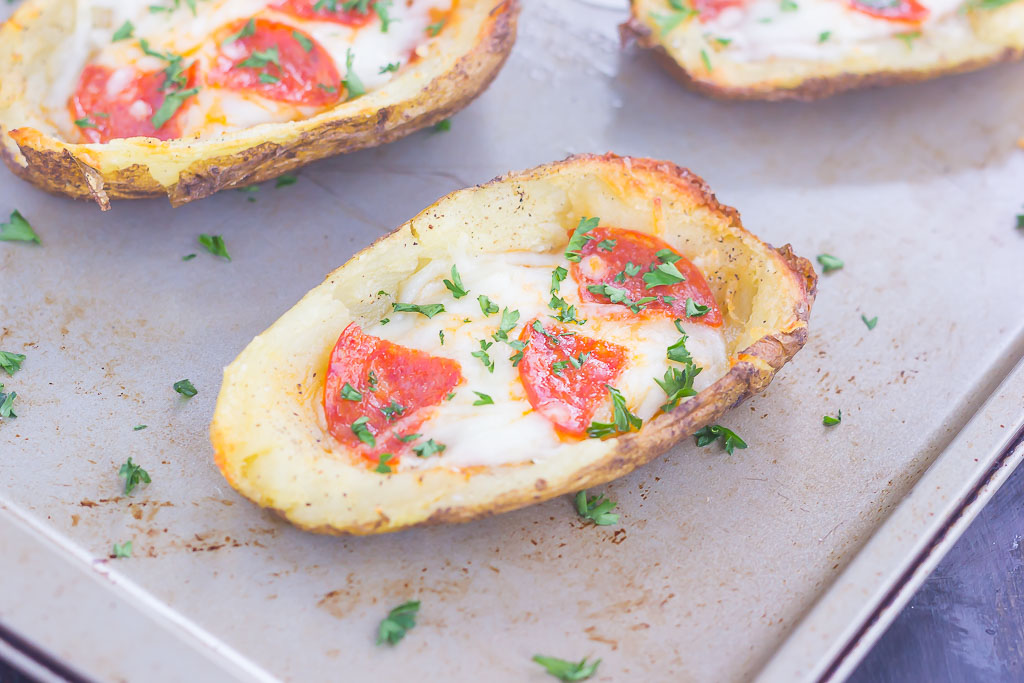 Three potato skin pizzas on a baking sheet. 