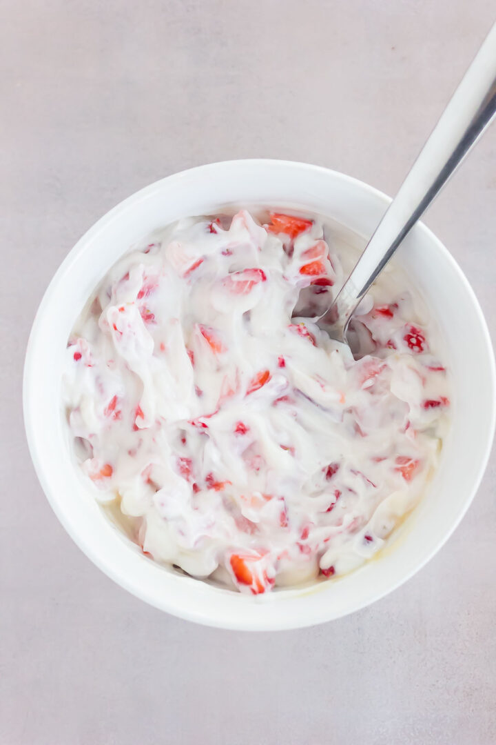 yogurt mixture in a white bowl with a metal spoon