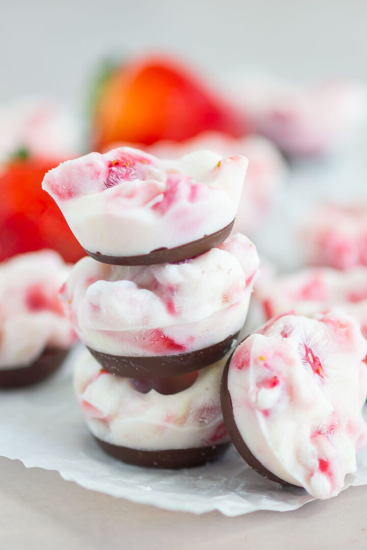 yogurt bites stacked on top of each other on white parchment paper