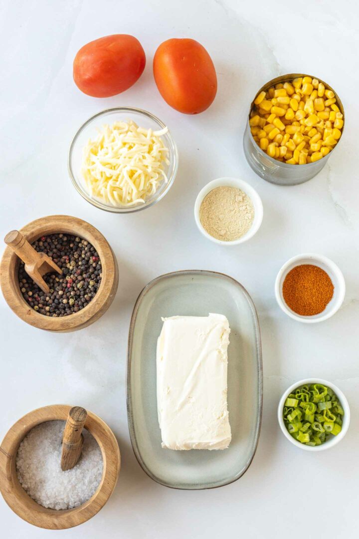 corn dip ingredients in small bowls on a white surface