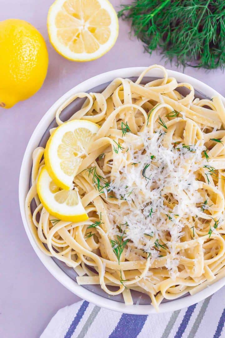 pasta in a white bowl with parmesan cheese on top