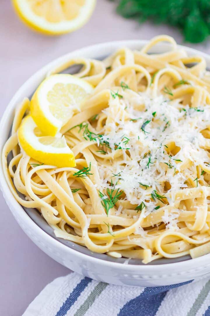 pasta in a white bowl with parmesan cheese on top