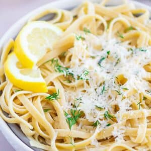 pasta in a white bowl with parmesan cheese on top