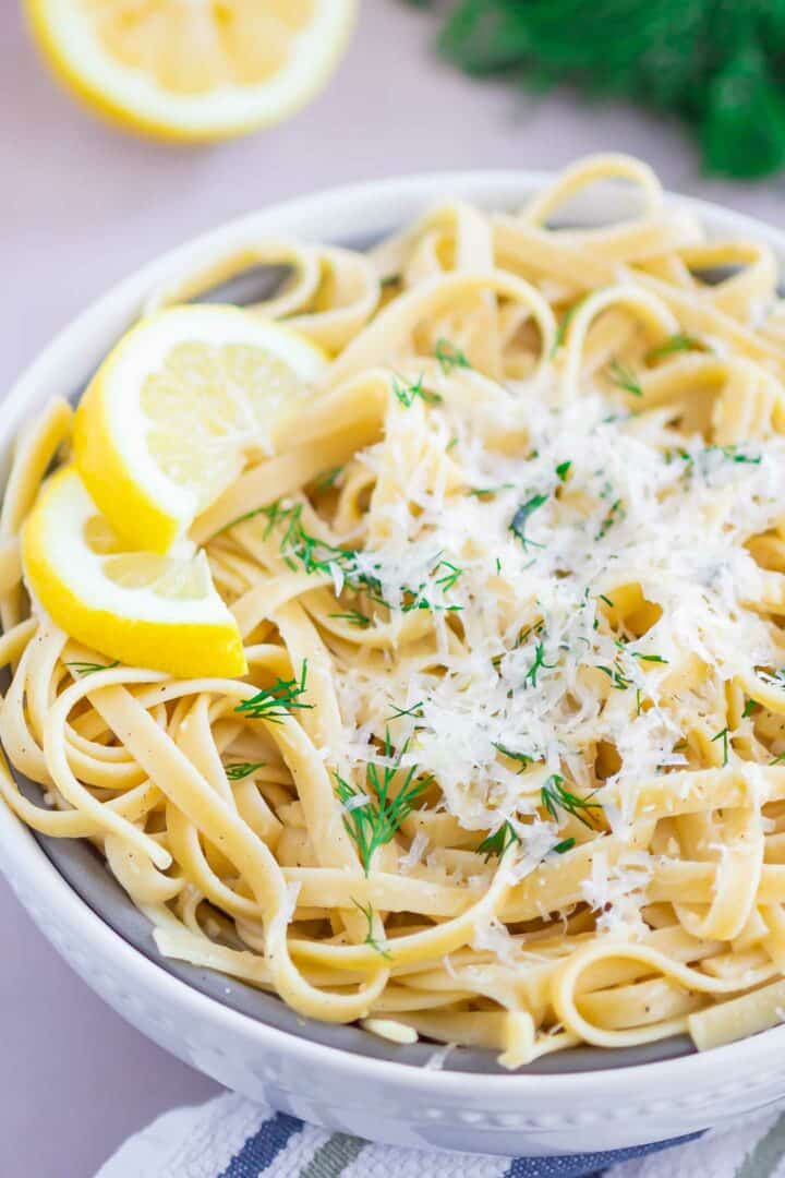 pasta in a white bowl with parmesan cheese on top