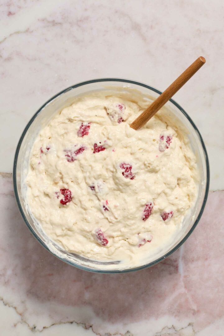 pancake ingredients being mixed in a bowl with a wooden spoon