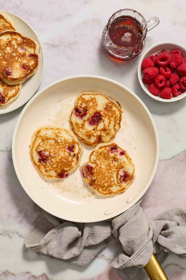 pancakes cooked and browned in a white skillet