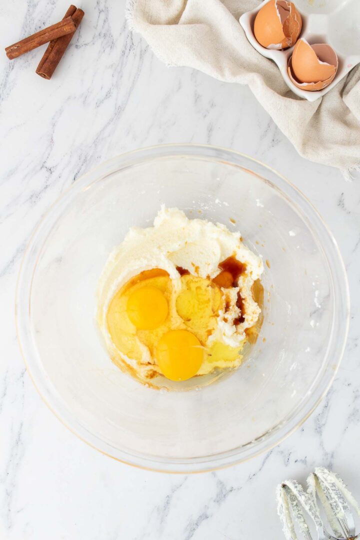 eggs and vanilla added to butter and sugar mixture in a glass bowl