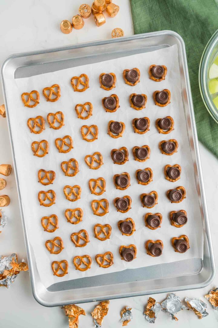 pretzels with rolos placed on top on a baking pan