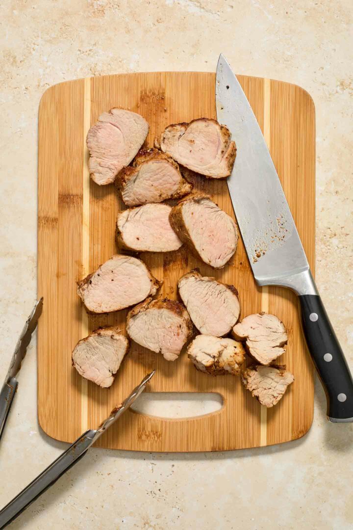 pork  tenderloin sliced on a wooden cutting board