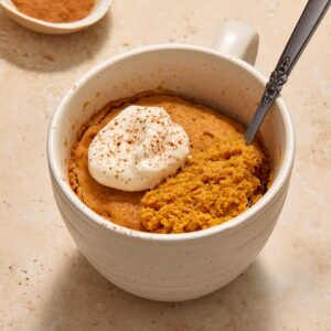 cake in a a white mug with whipped cream and a spoonful of cake