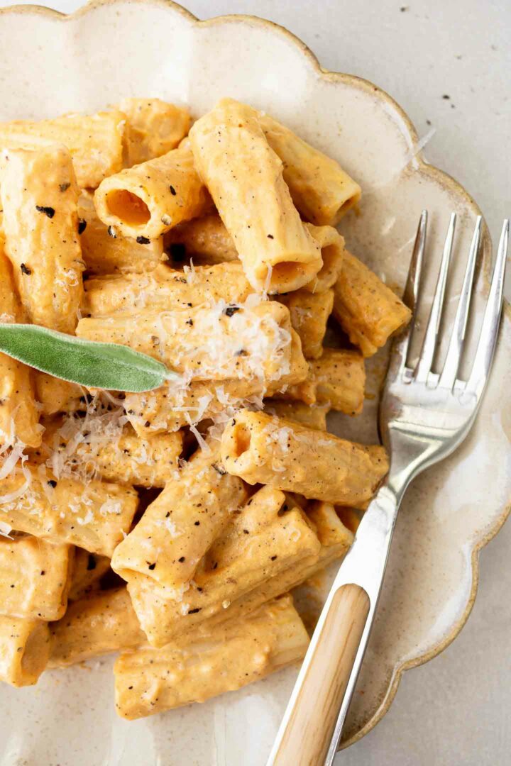 pumpkin alfredo pasta on a white plate with a silver fork