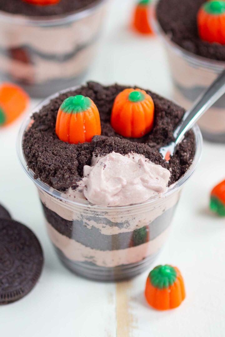 dirt cup on a white surface with a spoonful of pudding shown