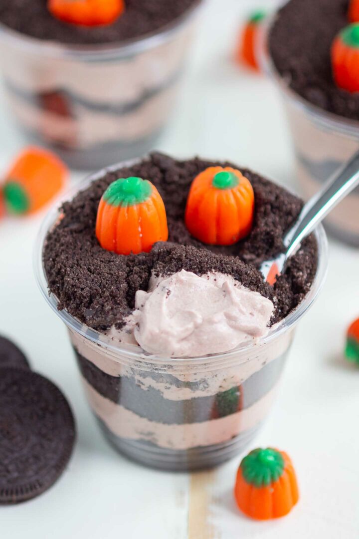 dirt cup on a white surface with a spoonful of pudding shown