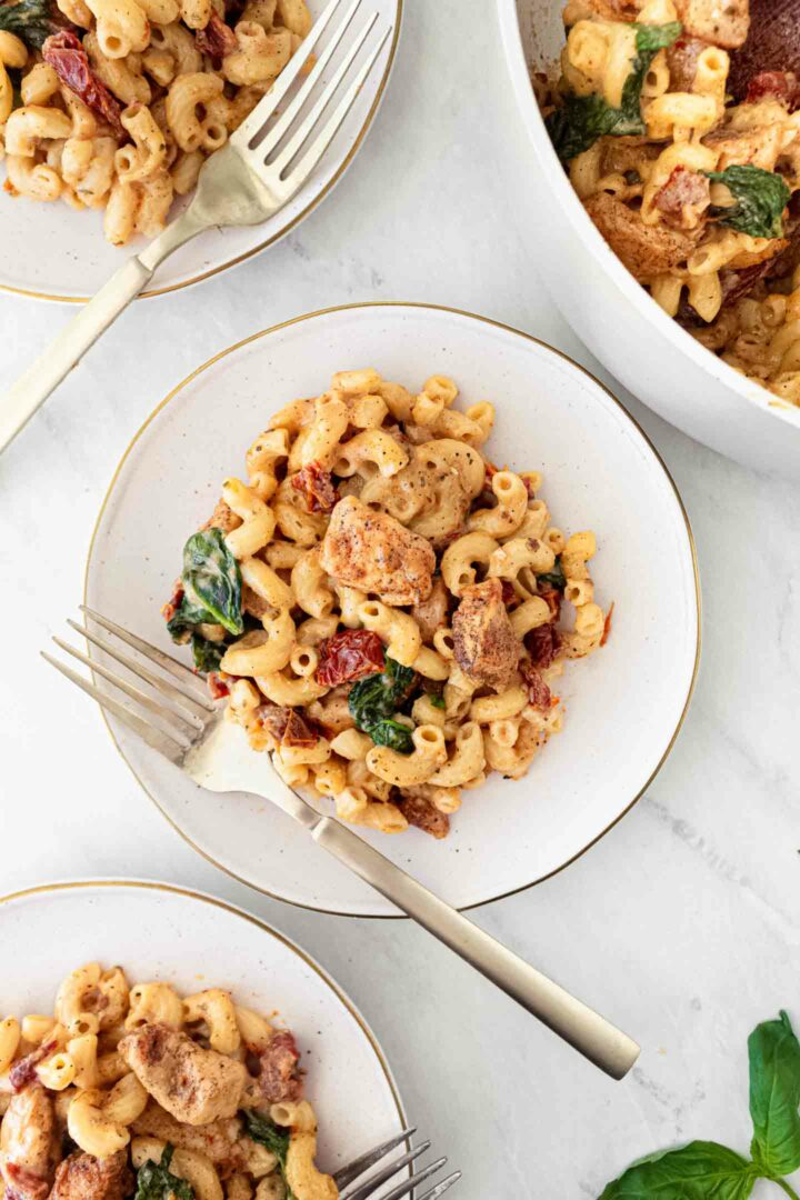 chicken mac and cheese on a white plate with a fork