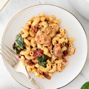 chicken mac and cheese on a white plate with a fork