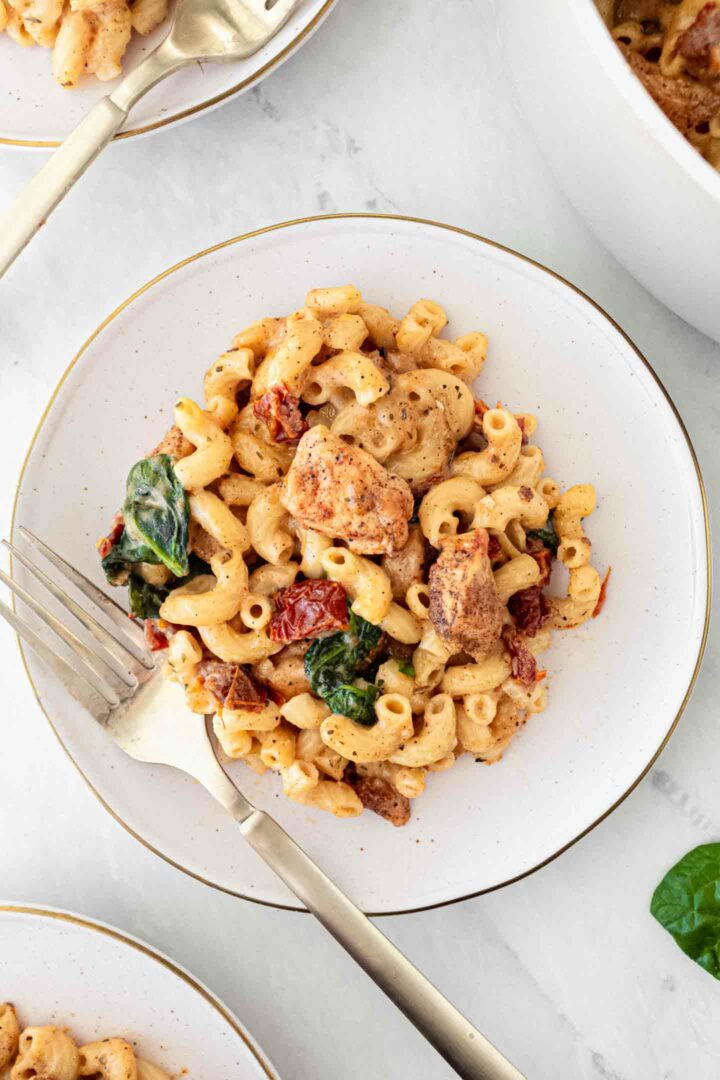 chicken mac and cheese on a white plate with a fork