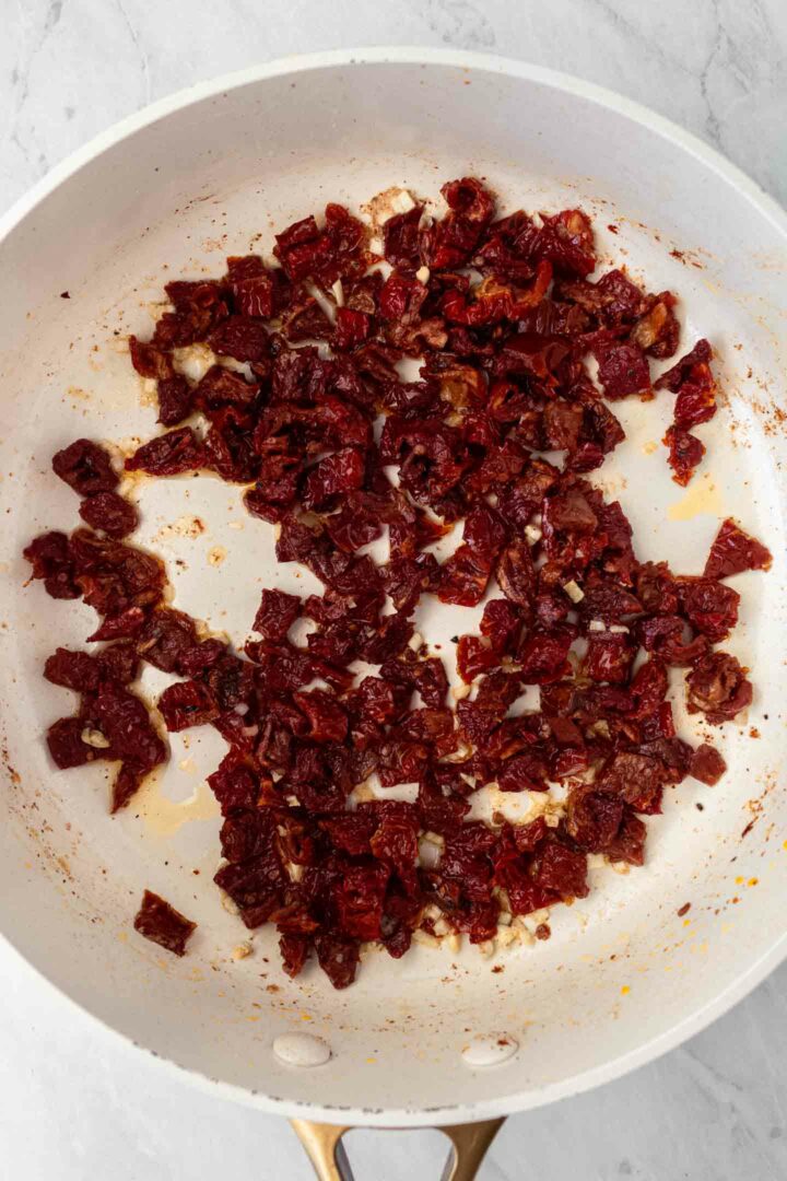 sun-dried tomatoes, milk, and spices added to skillet