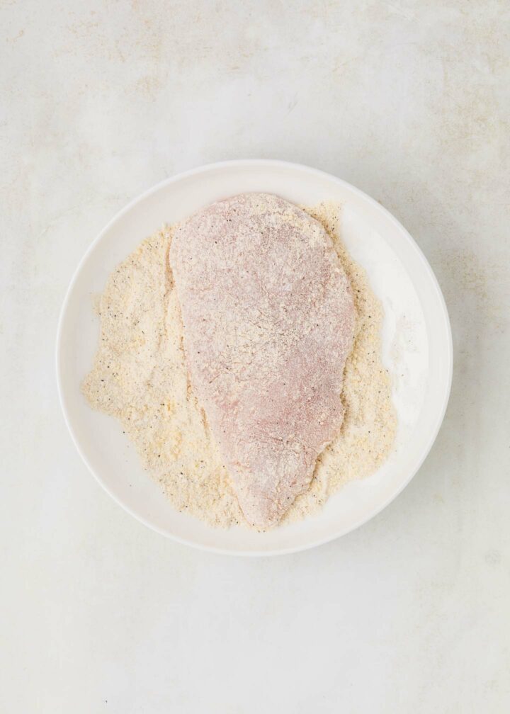 chicken dredged in flour mixture in a white dish