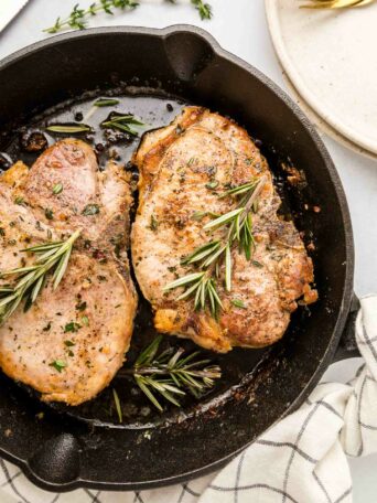 pork chops in a black cast iron skillet