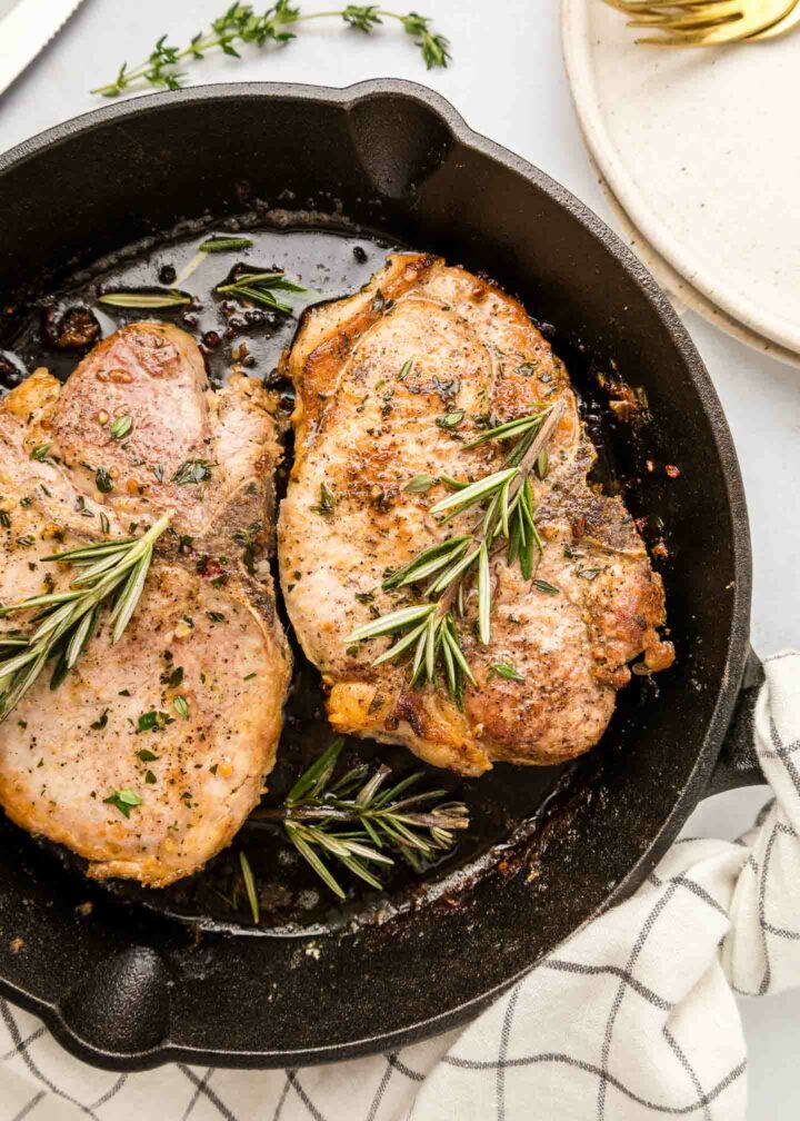 pork chops in a black cast iron skillet