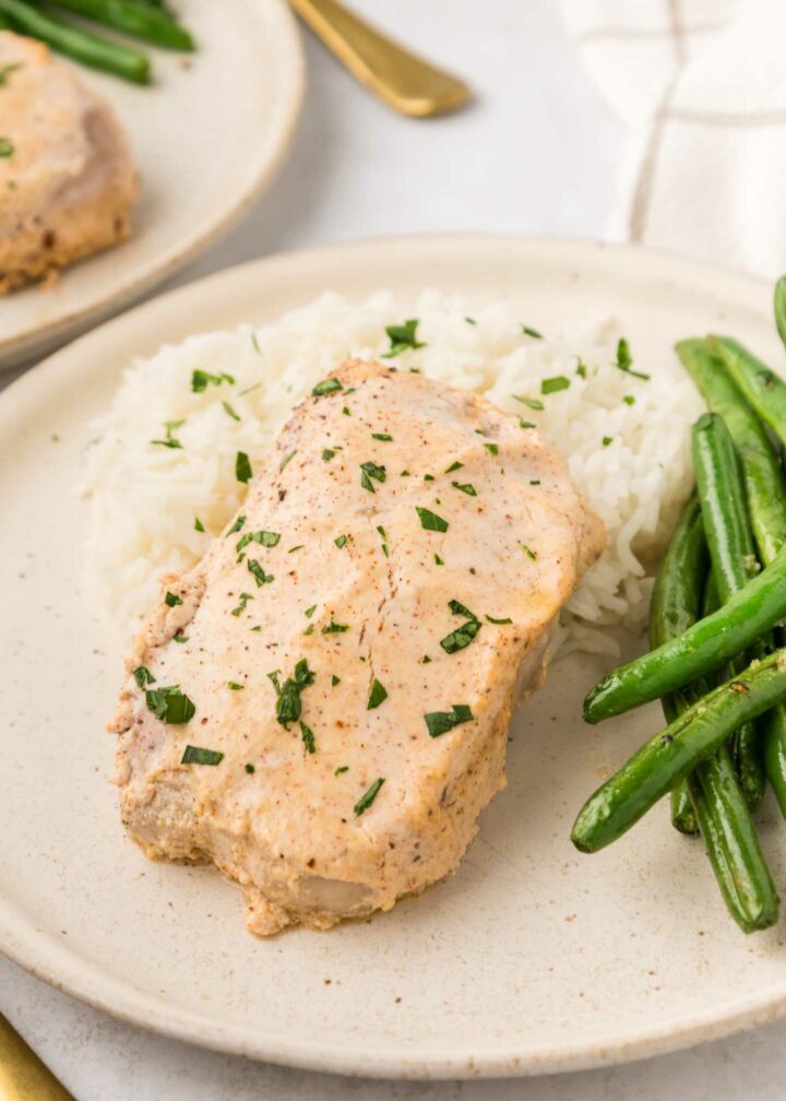 pork chops plated with mashed potatoes and green beans