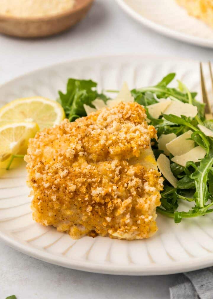 cod plate with a green salad and lemon slices