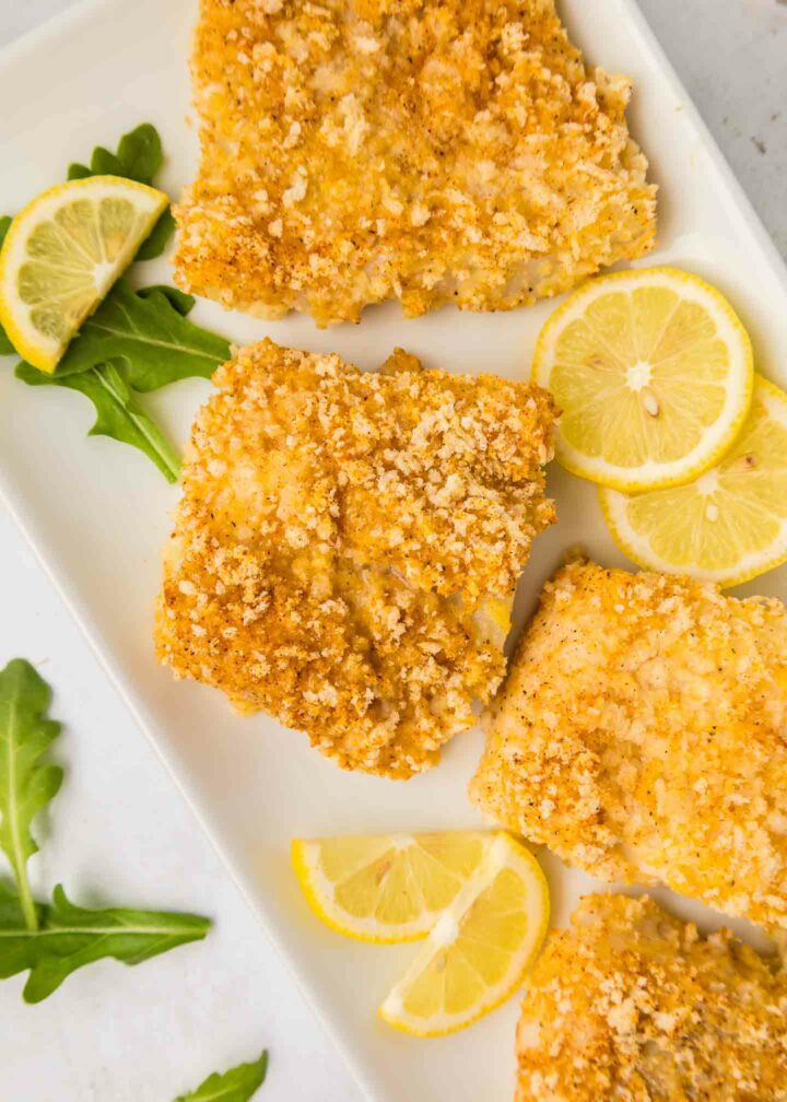 cod show on a white plate with lemon slices