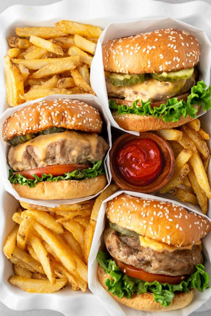 turkey burgers in a white dish with french fries