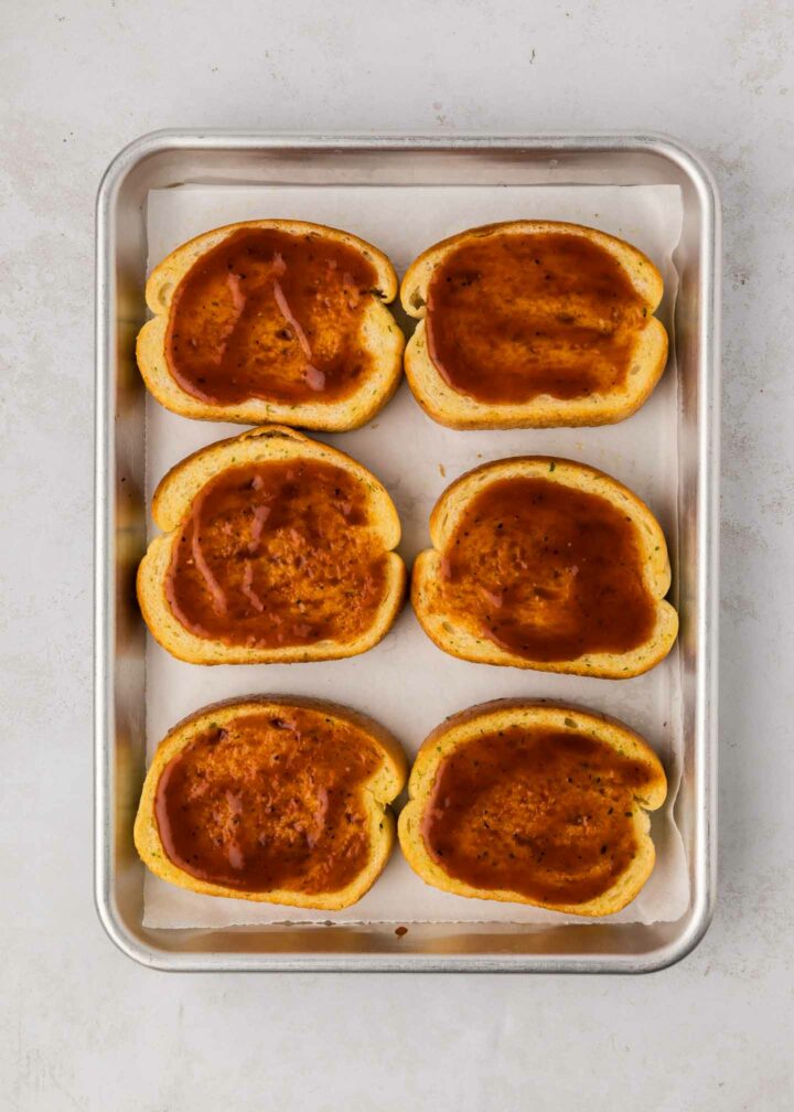 bbq sauce spread on top of toast on a sheet pan