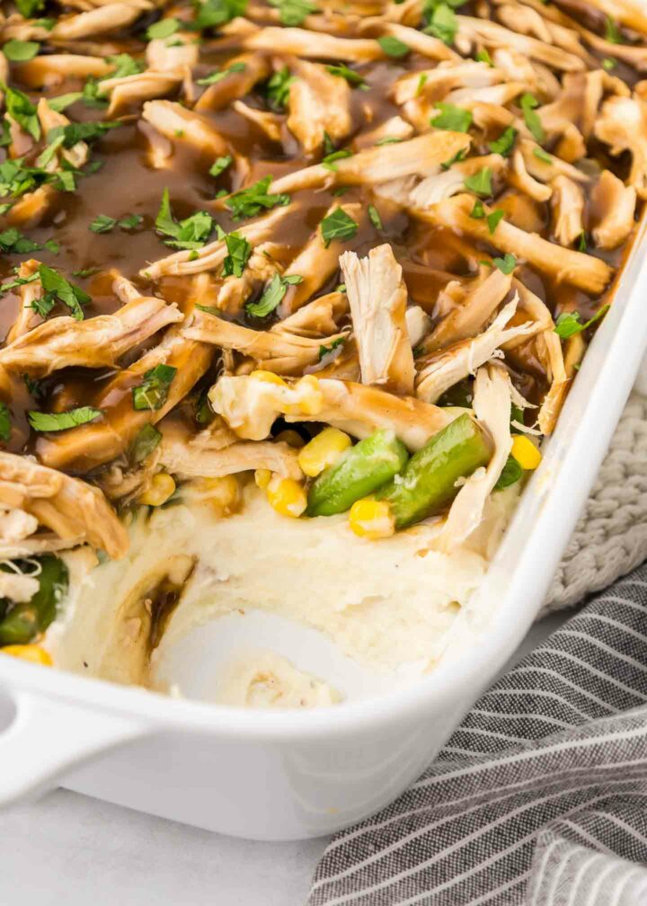 casserole in a white dish with a piece removed to show the filling