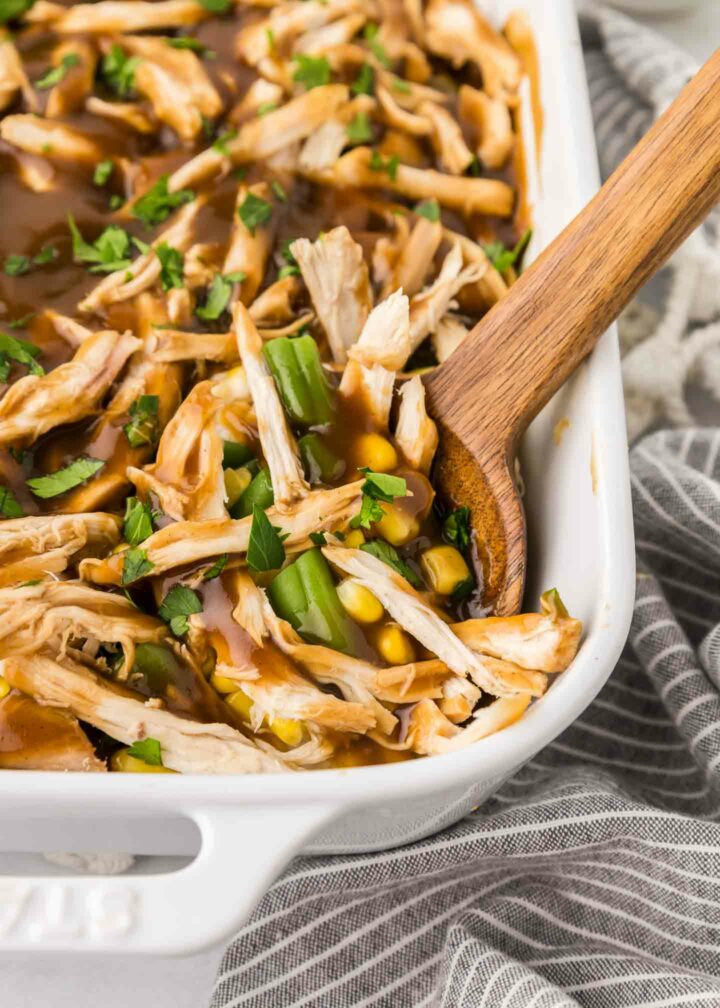 casserole in a white dish with a wooden spoon